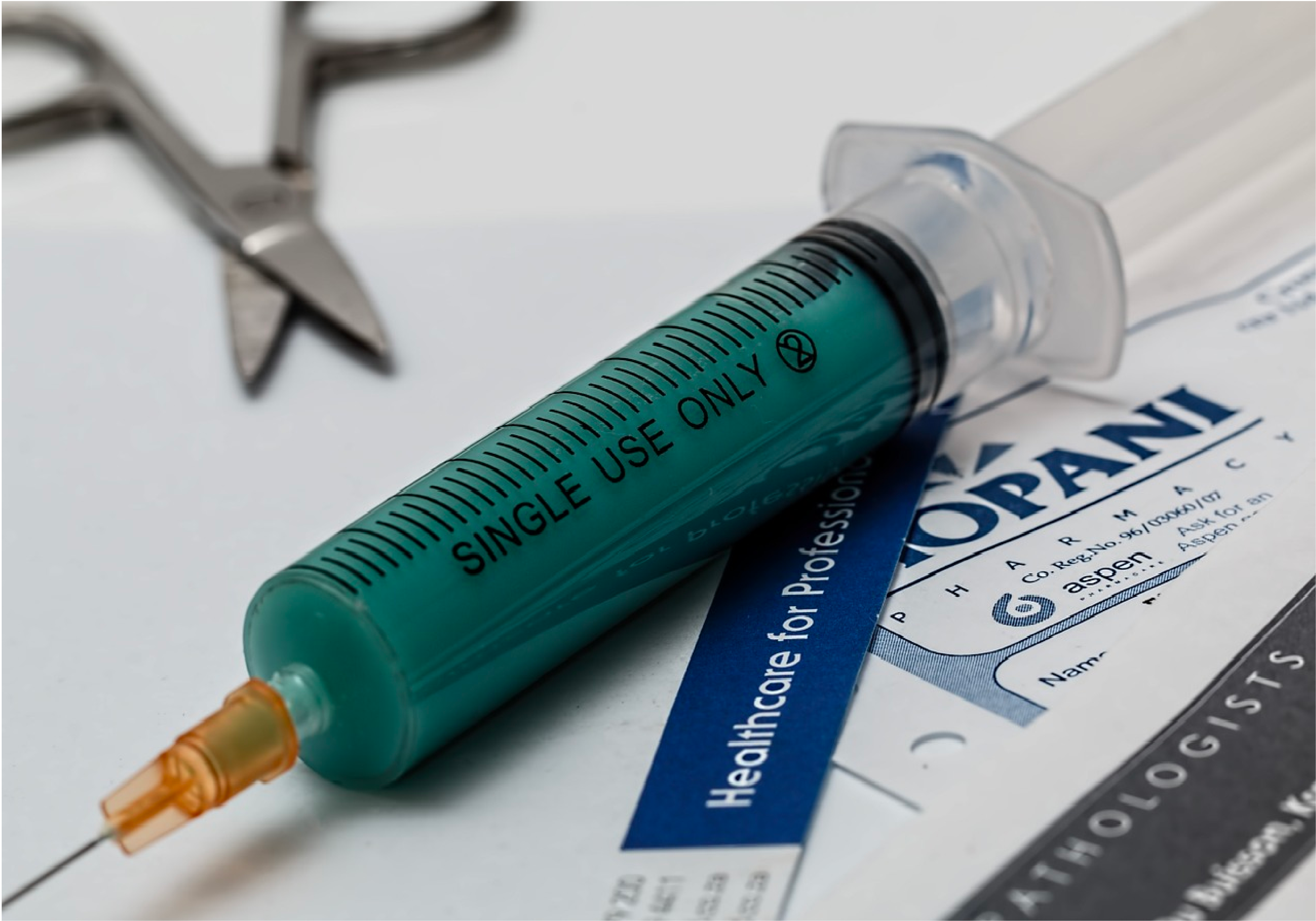 Immunizations Box: Close-up of a single-use syringe placed on top of a pharmacy instruction sheet, symbolizing immunizations or vaccine care.