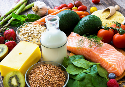 Nutrition Box: An assortment of healthy foods including fruits, vegetables, grains, dairy, and salmon arranged on a wooden surface.