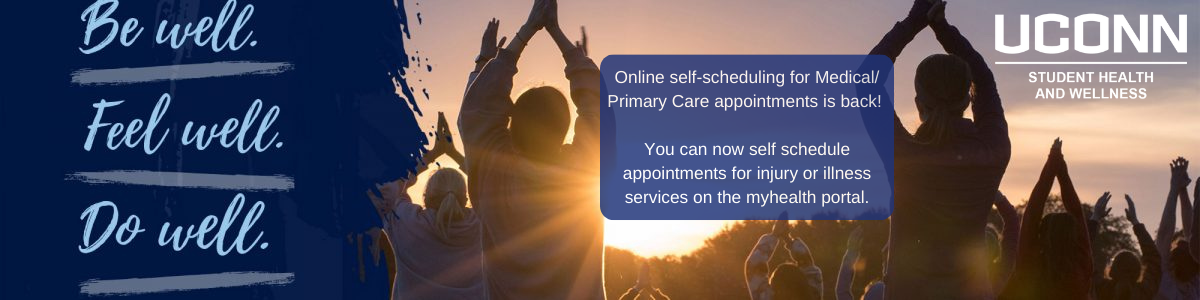 People at a sunset event raise hands in the air while a banner promotes UConn Student Health and Wellness online appointment scheduling.