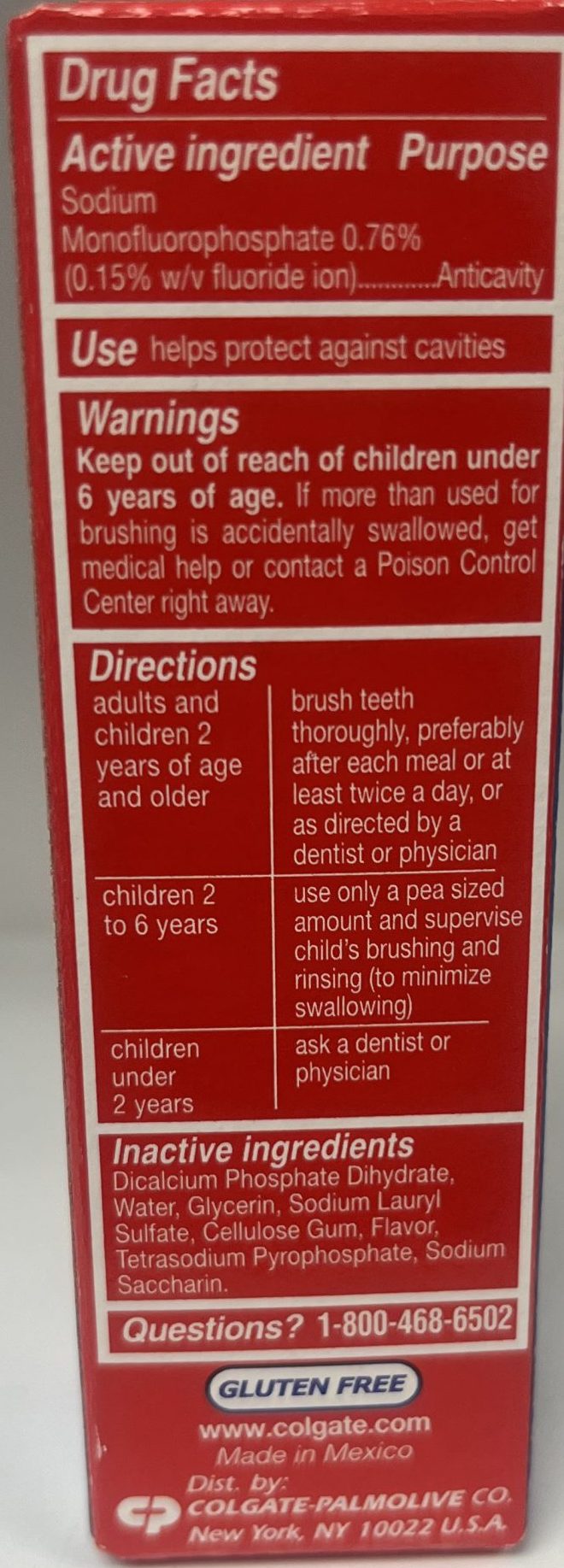 The back of a Colgate toothpaste package lists active ingredients, directions, warnings, and contact information for questions.