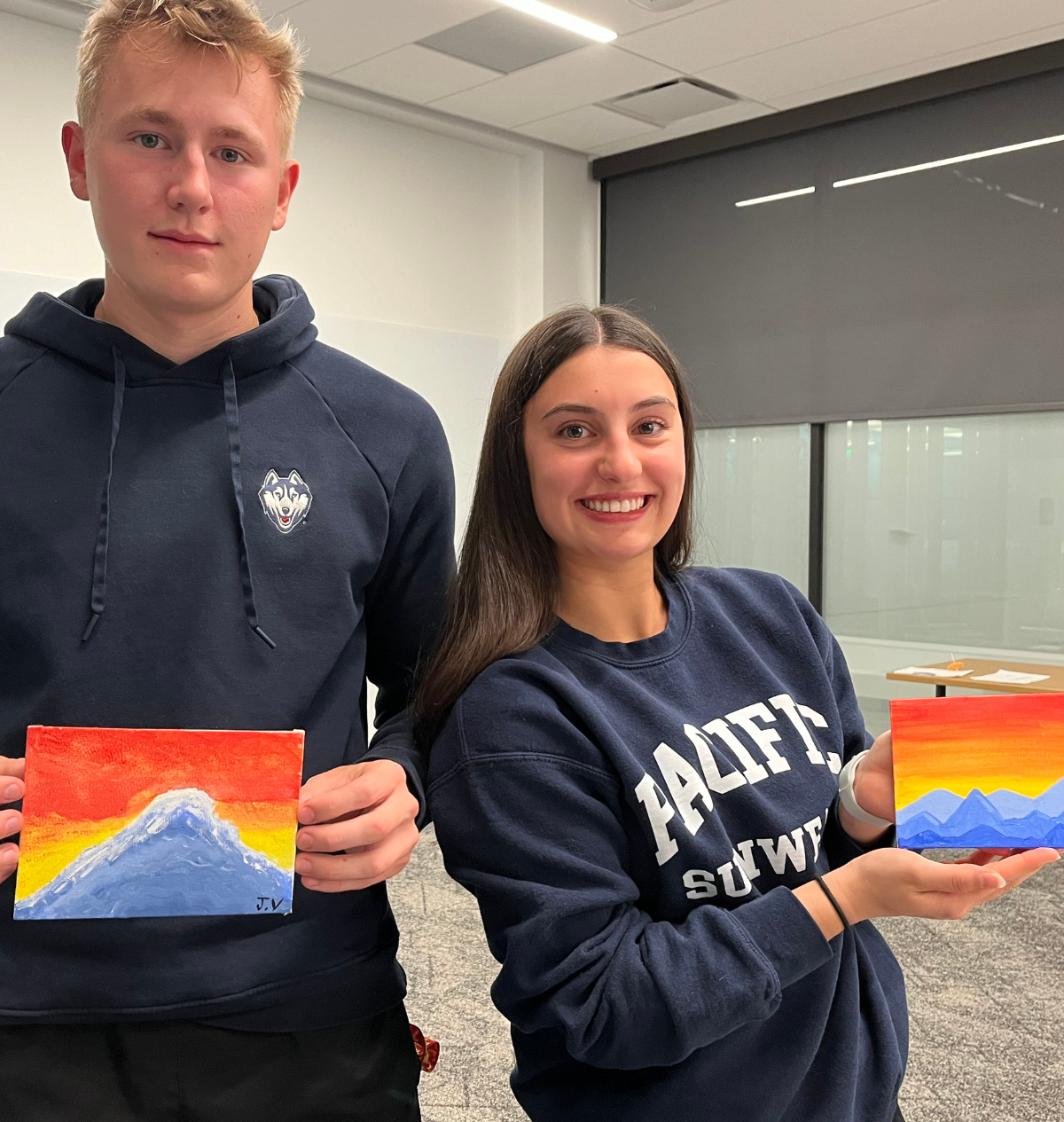Holistic Huskies painting3 Students proudly display their completed landscape paintings from a wellness-focused art session.