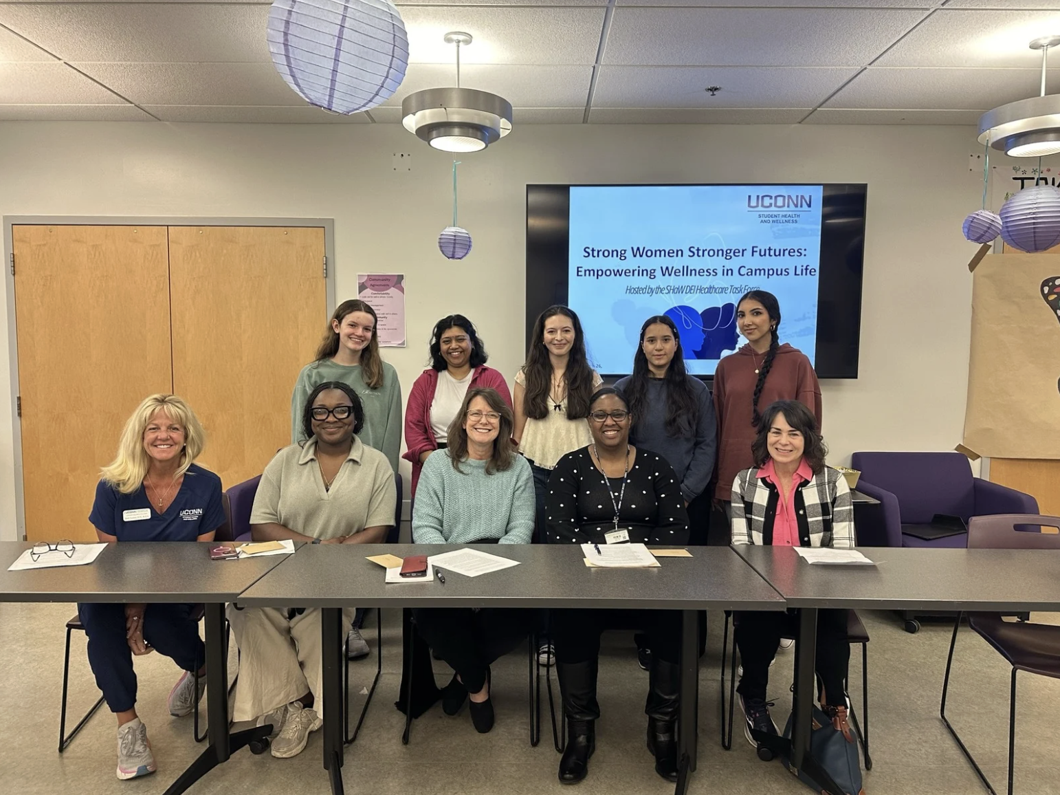 Group of students and staff pose after a UConn SHaW panel on empowering wellness in campus life.